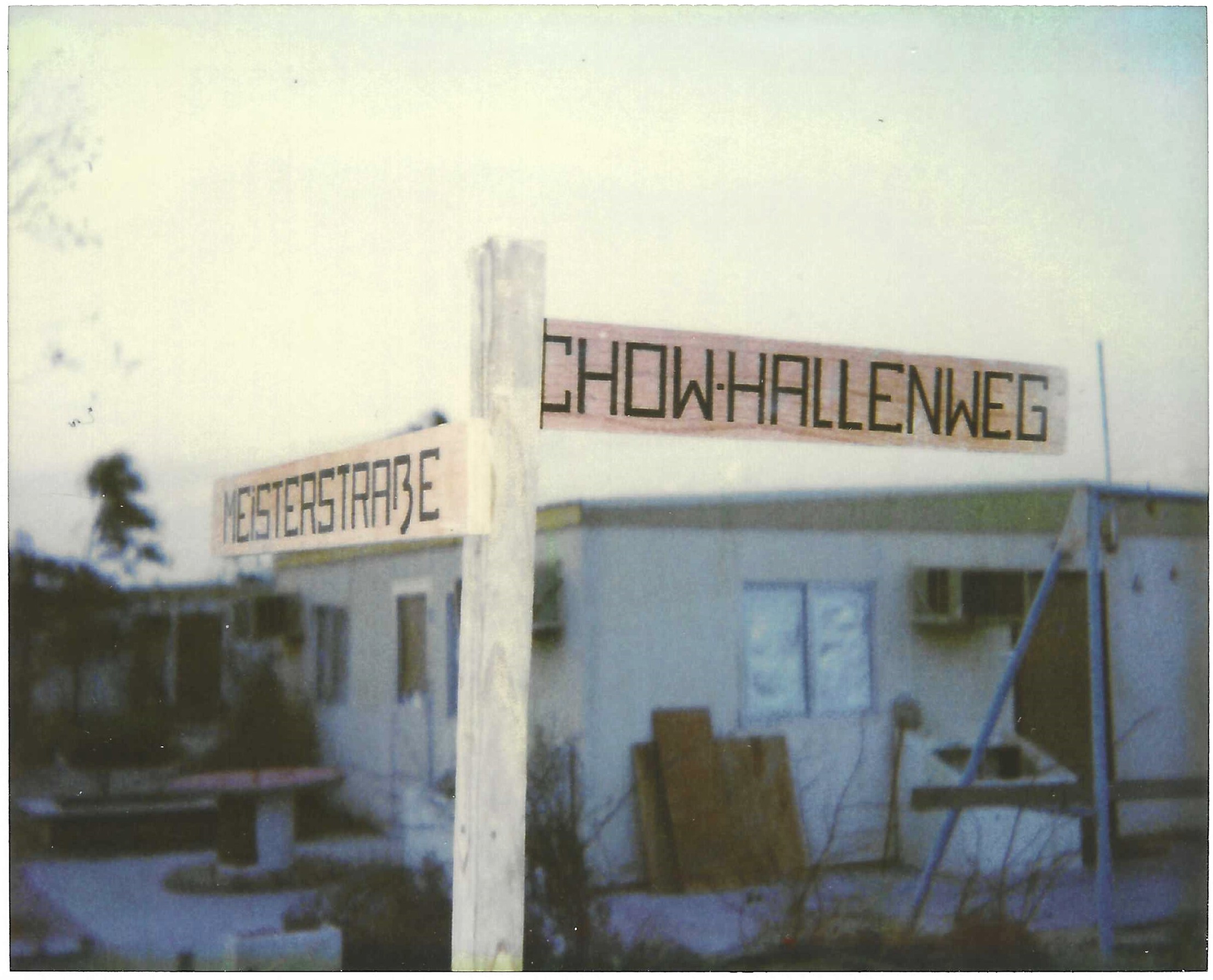 Hand-painted street signs — German precision applied to a Saudi tent city.