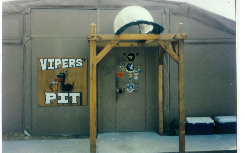 The squadron bar at Al Minhad — patches on the wall, beer on the table, the cease-fire still warm.